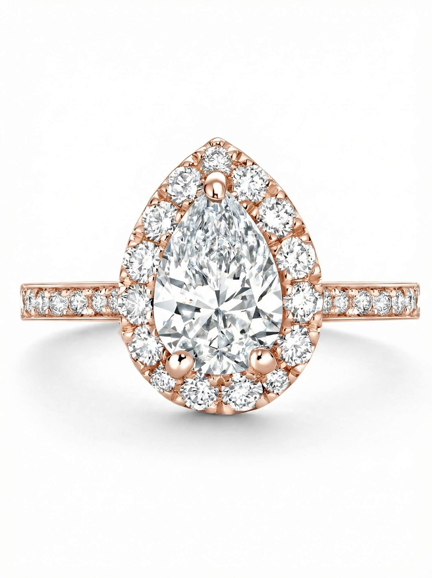 Rose gold ring with a pear-shaped diamond and halo of smaller diamonds on a white background