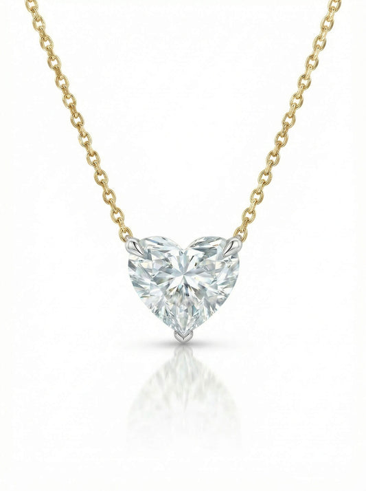 Heart-shaped diamond pendant on a gold chain against a white background