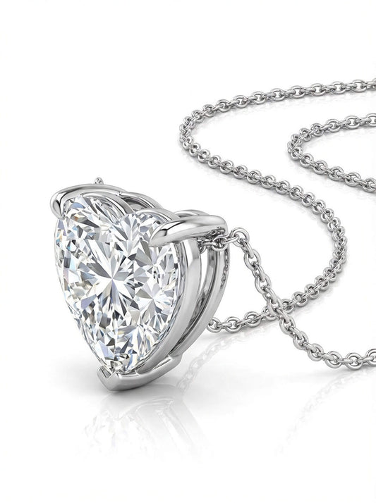 Heart-shaped diamond pendant on a chain against a white background