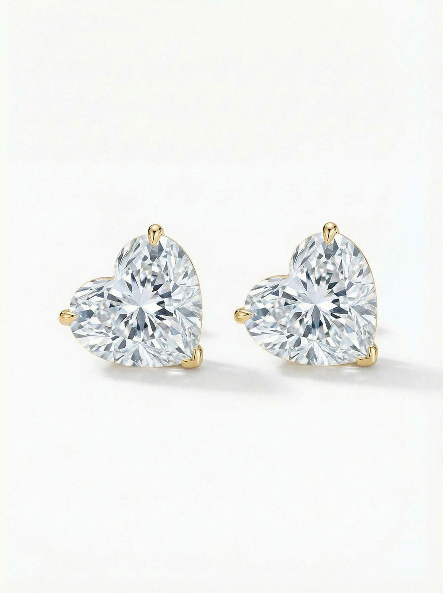 Pair of heart-shaped diamond earrings on a white background