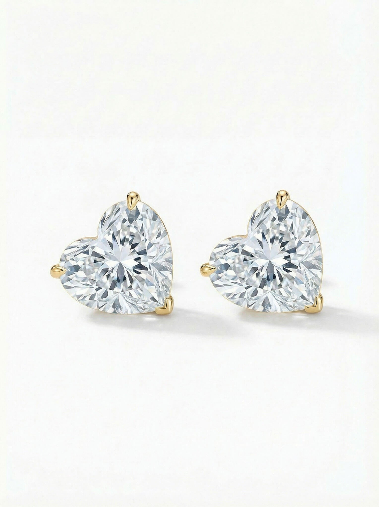 Pair of heart-shaped diamond earrings on a white background