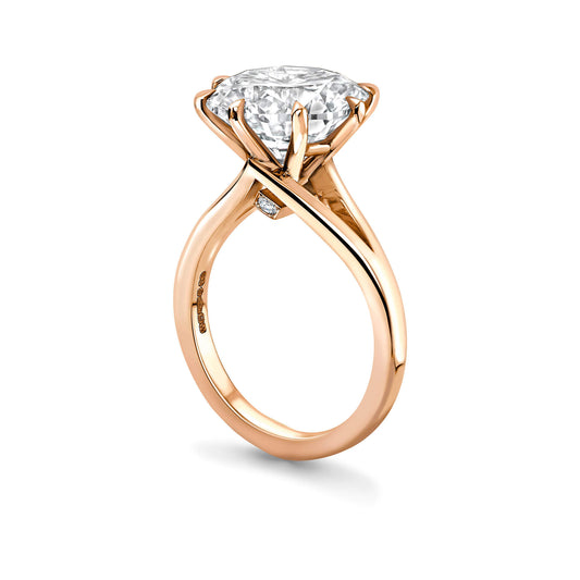 Rose gold ring with a large diamond on a white background