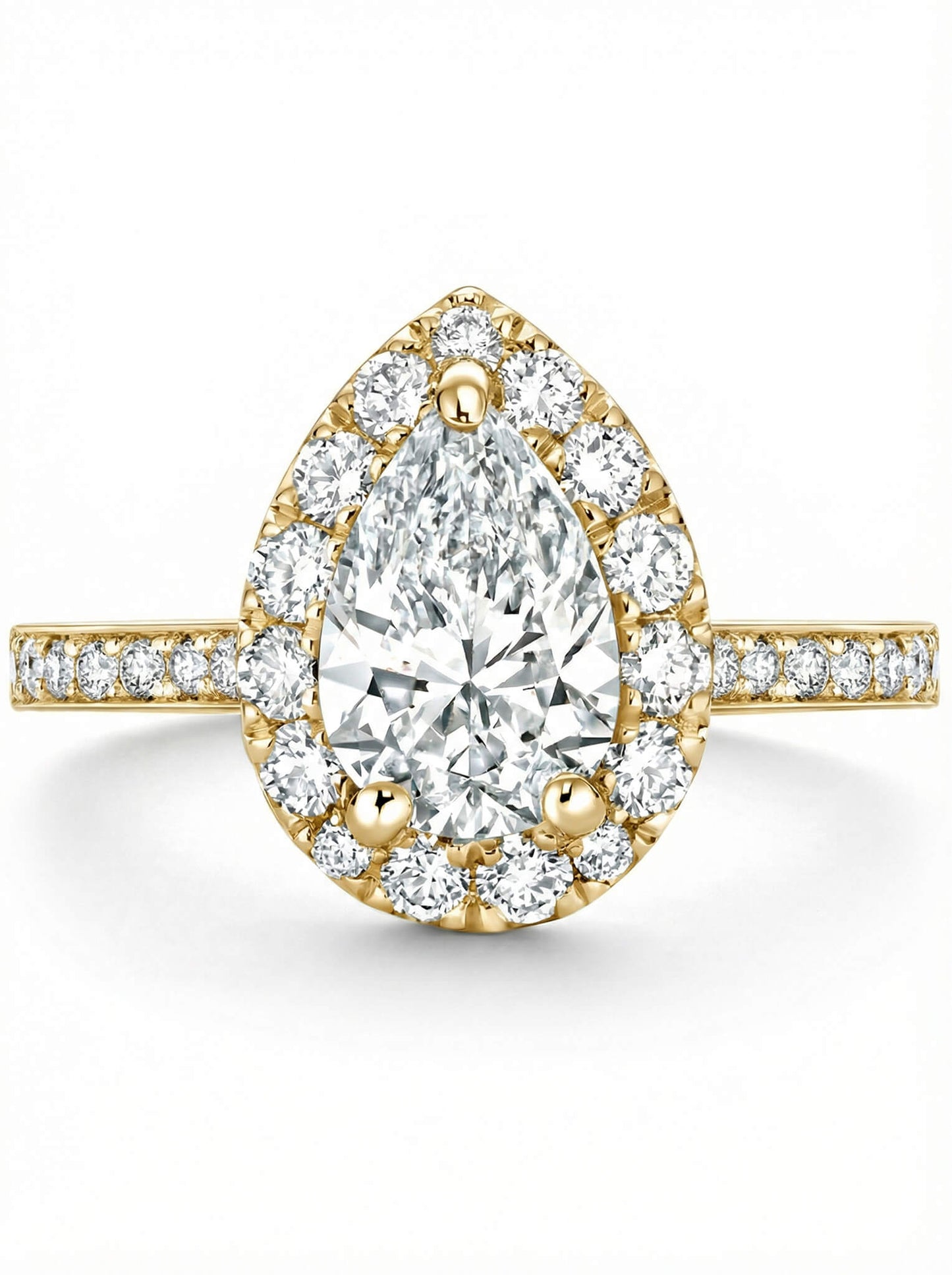 Gold ring with a pear-shaped diamond with a halo of smaller diamonds on a white background.