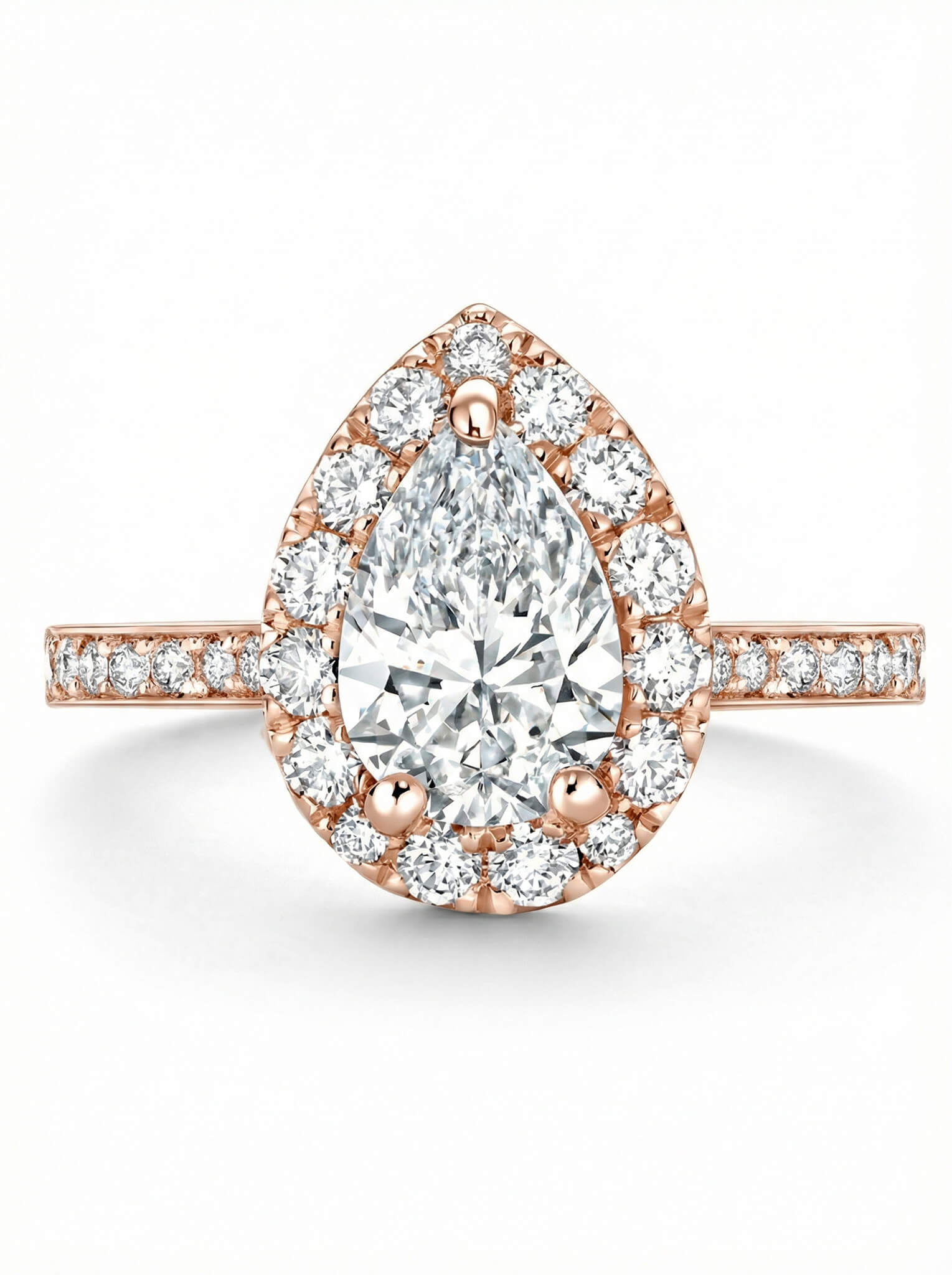 Rose gold ring with a pear-shaped diamond and halo of smaller diamonds on a white background