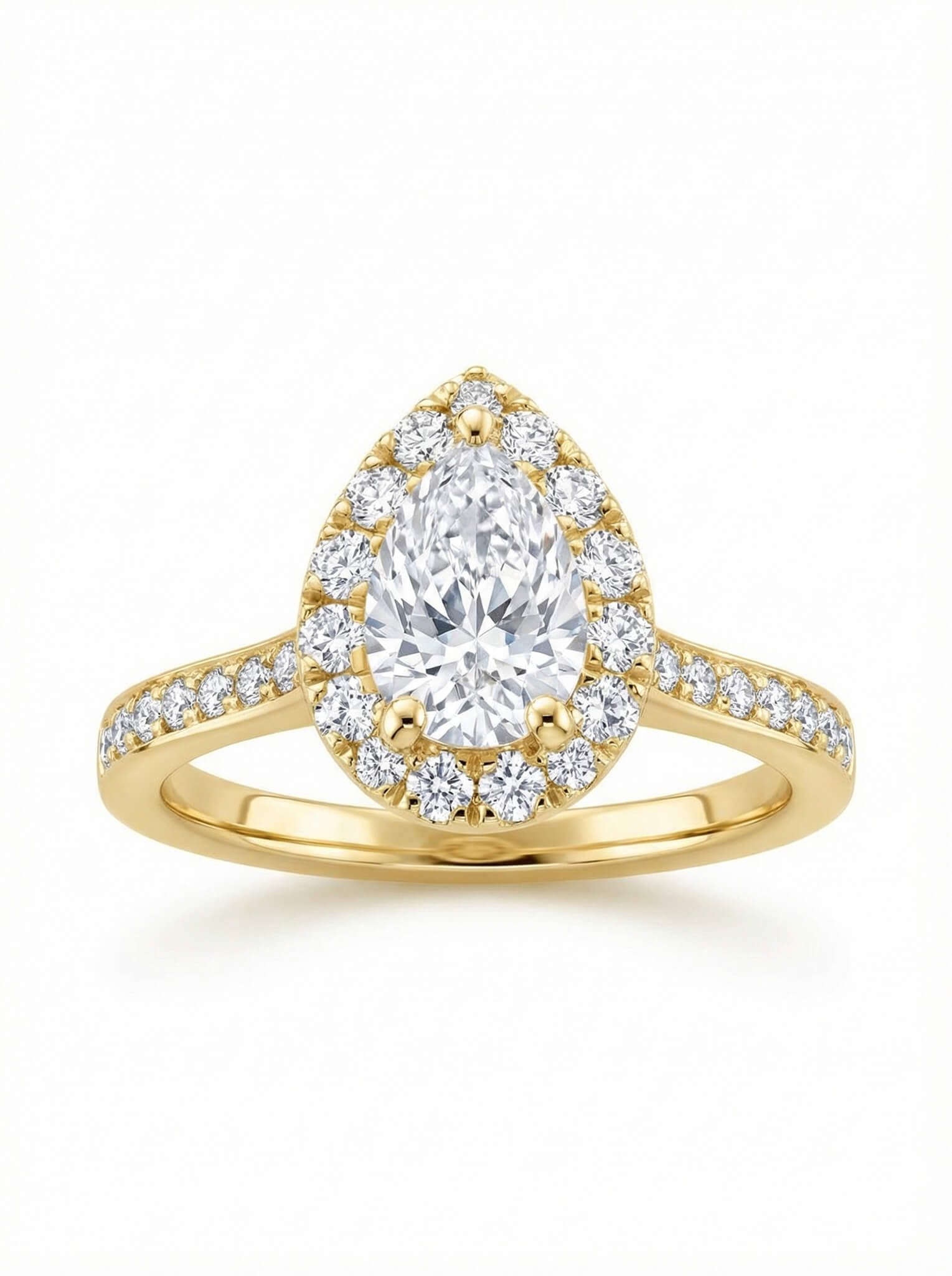 Gold ring with a pear-shaped diamond surrounded by smaller diamonds on a white background.